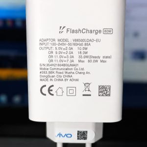 Close-up of a white FlashCharge 80W mobile charger with technical specifications, showing input and output details along with the "vivo" logo and certification symbols.